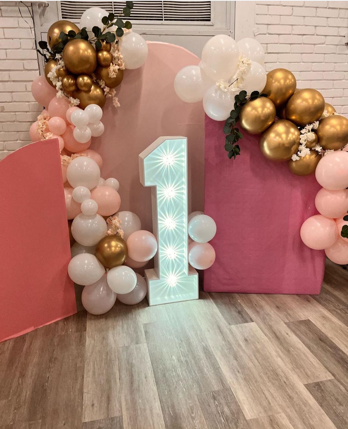 Pink, white and gold balloon garland with light-up number 1 and pink backdrops