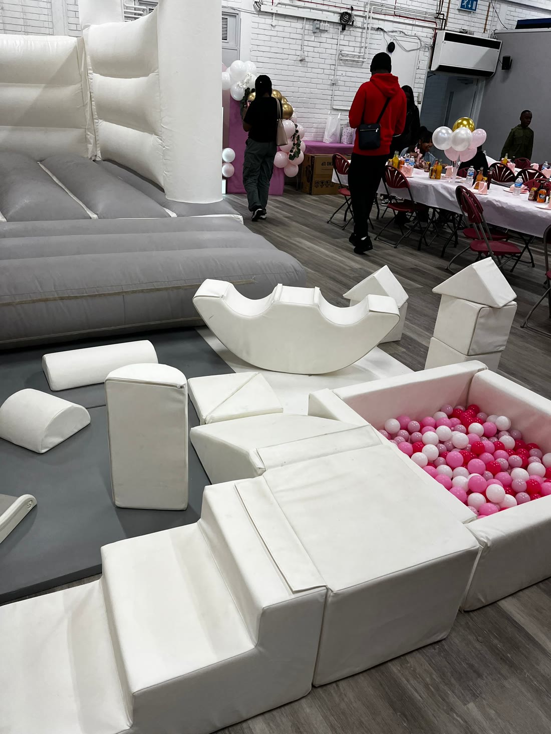 Soft play and ball pit with party tables styled in pink, white & gold