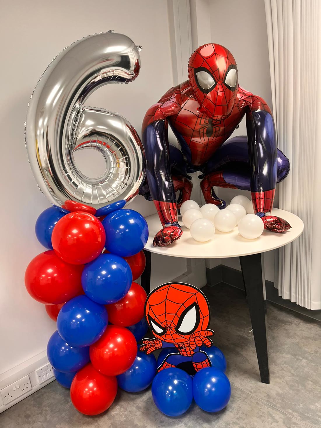 Spider-Man themed balloon column with silver number 6 and foil balloon display